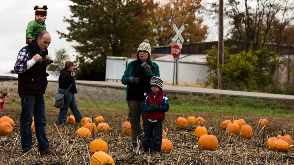 Scott and Rachel Gottshall, along with Emory (on Scott's shoulders) and Amos, mull over pumpkin options.