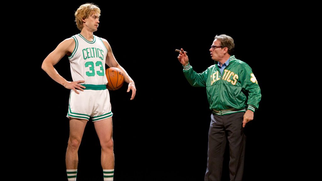Larry Bird (played by Tug Coker, left) and Boston Celtics executive Red Auerbach (Peter Scolari) discuss the budding superstar's role in the Celtics' scheme.