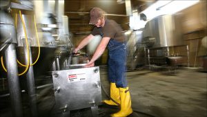Sun King's Jon Simmons cleans out filters used in brewing.