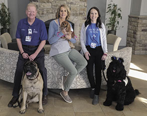 Group photo of three members of Ascension St. Vincent's Paws to Heal, a Paws to Think program, each accompanying a dog