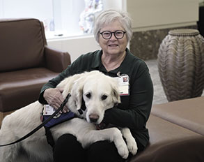Photo of Sherry Brown holding Naomi the Comfort Dog on her lap