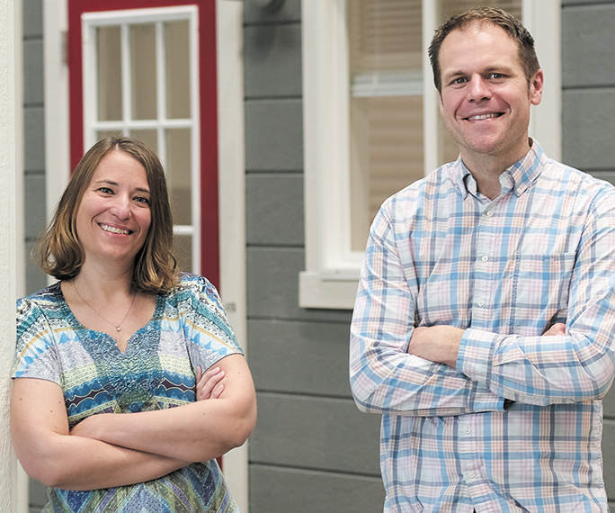 FullStack CEO Dawn Lively and Vice President Daniel Fuller with arms crossed on a porch