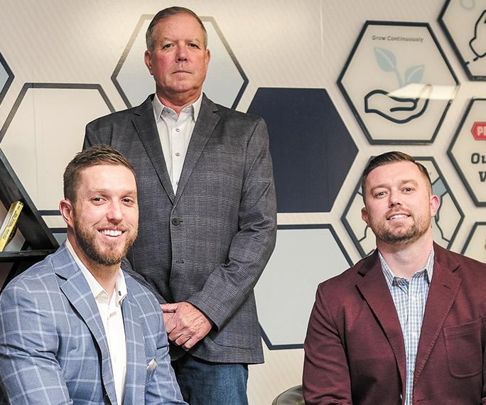 Peterman Brothers owners Tyler Peterman, Pete Peterman and Chad Peterman in front of a hexagon-designed wall