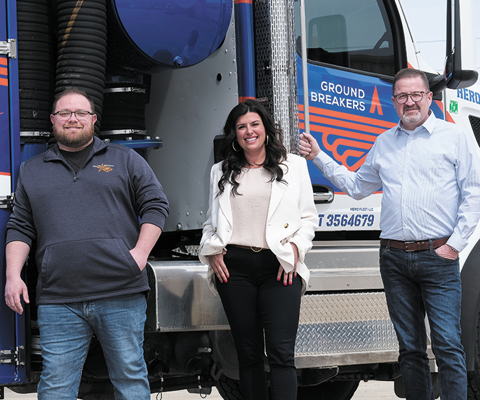 GroundBreakers Director of Operations Doug Taylor, President Andrea Sloan and Chief Operating Officer Rob Douglas posing in front of a tractor-trailer