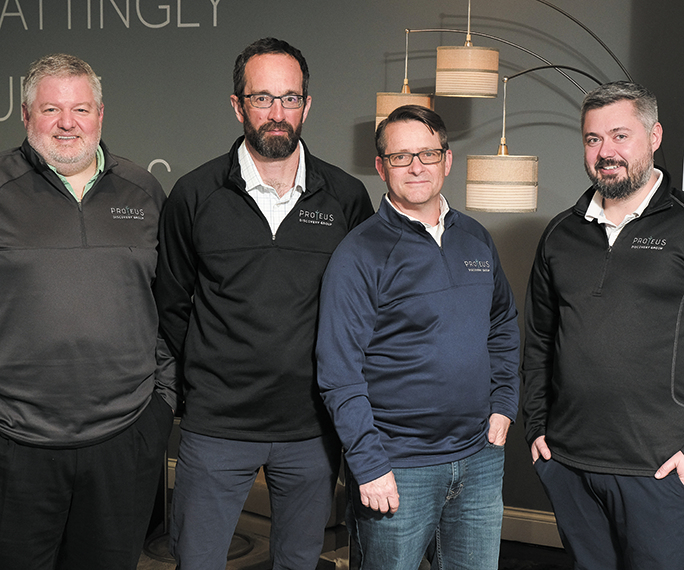 Medium shot of Proteus Discovery Group co-founders Jon Mattingly, Hamish Cohen, Sean Burke and Ray Biederman in matching Proteus branded quarter zips