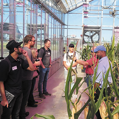 A group of Fall 2022 fellows in Purdue University’s DIAL Ventures startup studio program listen to a speaker in a greenhouse