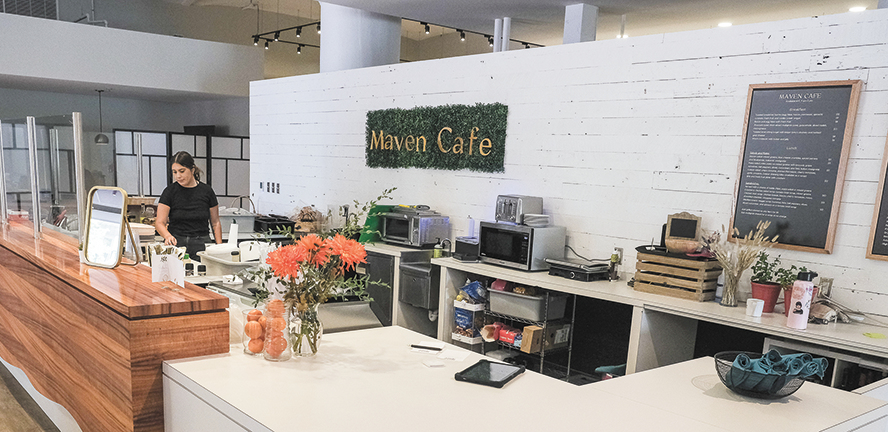 Photo of a cafe counter behind which a sign reads Maven Cafe