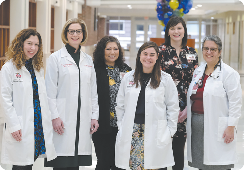 Group photo of Dr. Emily Sims; Dr. Carmella Evans-Molina; Maria Spall;
            Dr. Jamie Felton; Anna King and Dr. Linda DiMeglio in a hospital corridor