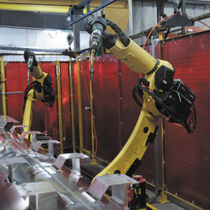 A pair of yellow mechanical arms positioned over an assembly line