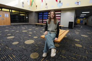 Makenzie Gilkison sits in the lobby at Greenfield Central High School, Tuesday, Dec. 17, 2024, in Greenfield, Ind. (AP Photo/Darron Cummings)