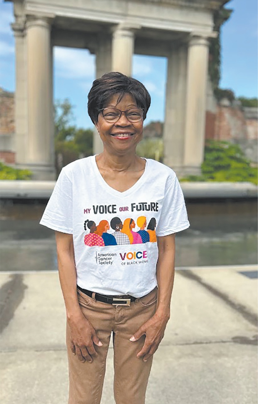 Dr. Carmon Hicks smiles at the camera wearing a My Voice Our Future T shirt