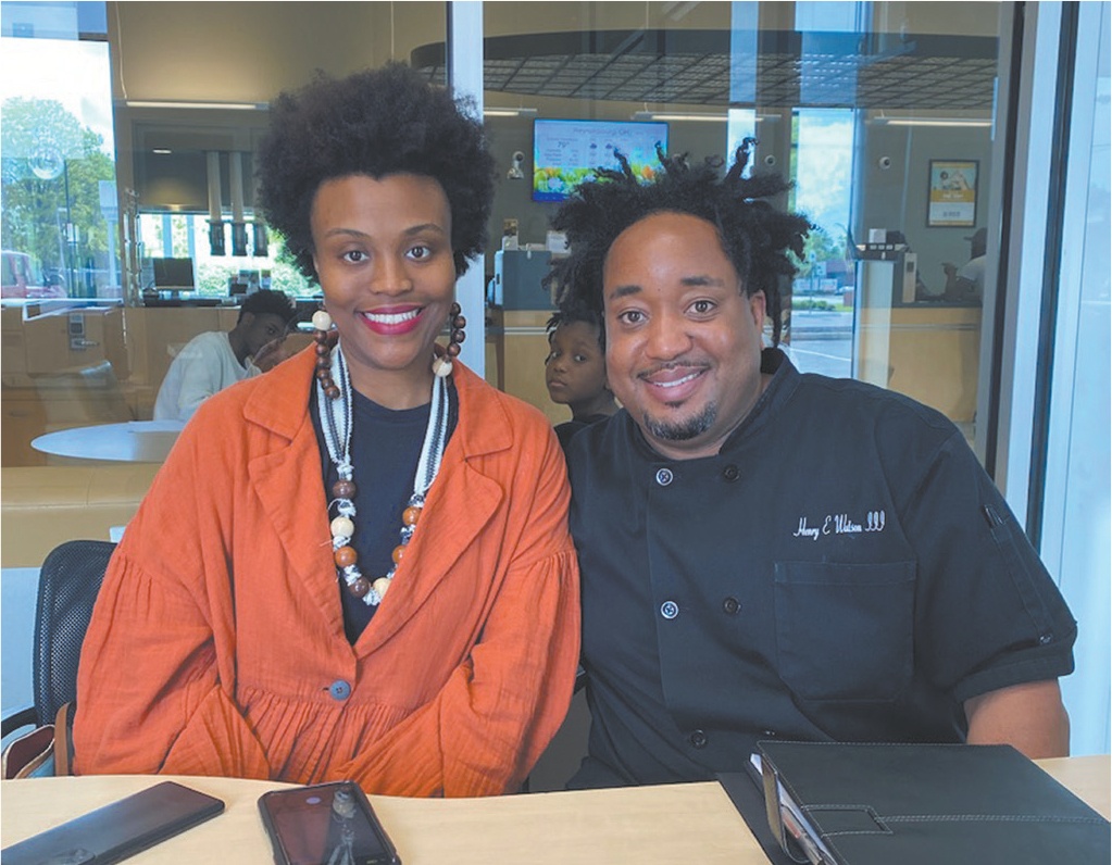 A couple seated in a bank office smile at the camera