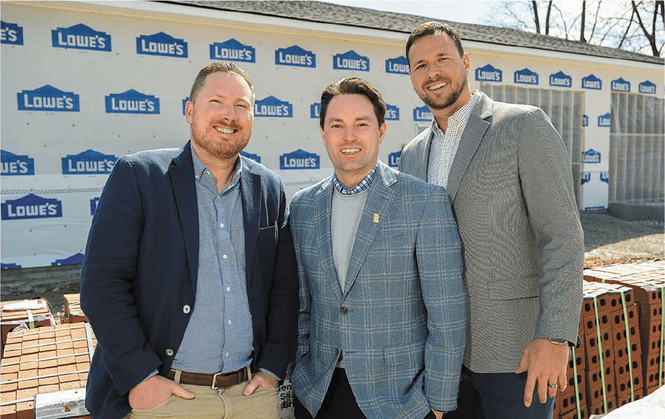 3 members of Secured Tech posed in front of a building under construction