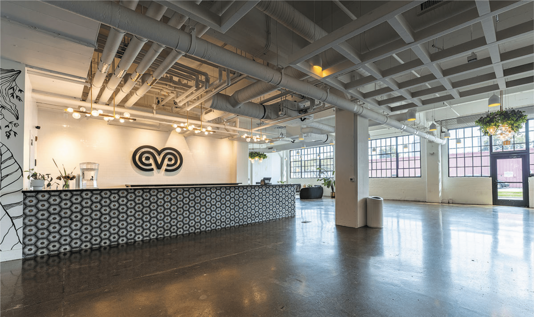 Photograph of the VisionLoft events space. Large industrial style windows fill the room with sunlight.